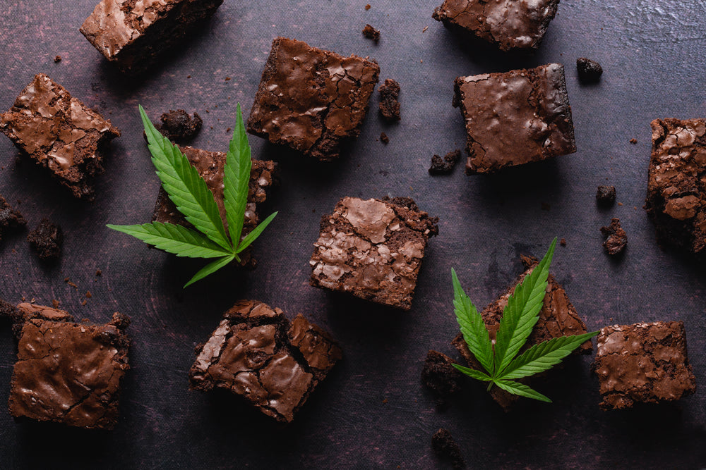Pot brownies sit among cannabis leaves.